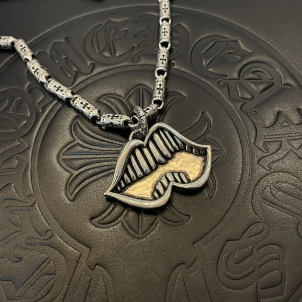 Unique Chrome Hearts necklace with gold teeth mouth pendant, crafted with detailed gothic elements.
