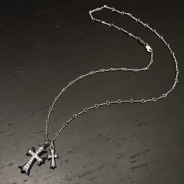 Bold Chrome Hearts silver necklace with dual cross pendants, perfect for layered gothic streetwear looks.