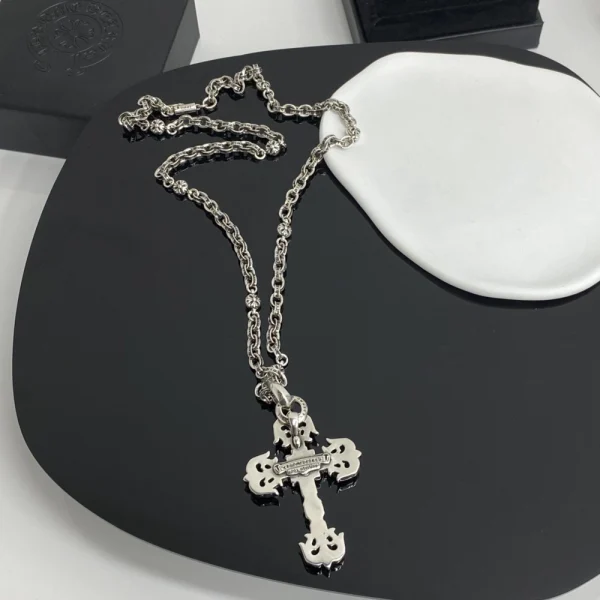Chrome Hearts filigree cross charm necklace in sterling silver with intricate gothic detailing.