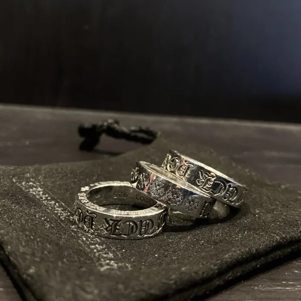 Chrome Hearts bold statement ring in sterling silver with edgy engraved phrase and gothic design.