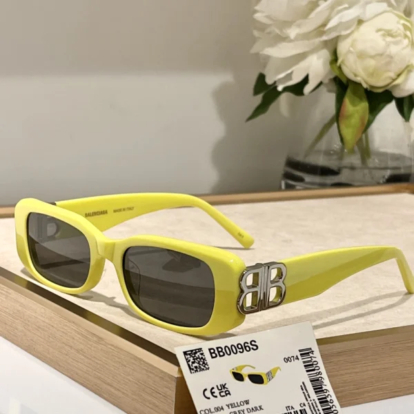 Balenciaga Dynasty rectangle sunglasses placed on white surface, highlighting thick frame and engraved branding