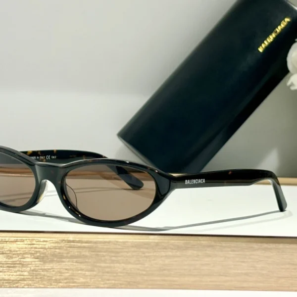 Close-up of Balenciaga Neo round sunglasses crafted from glossy acetate with metallic logo accent