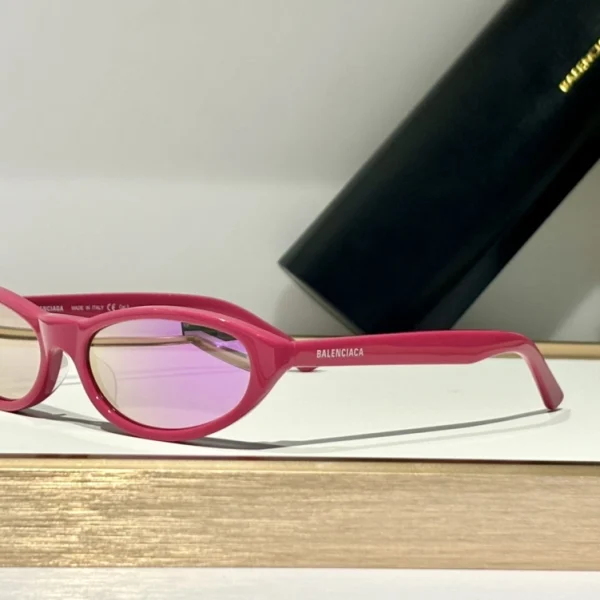 Flat lay of Balenciaga Neo round sunglasses with branded box and accessories