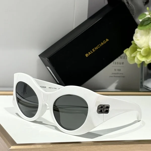 Balenciaga round sunglasses laid flat on white surface with smooth, curved frame