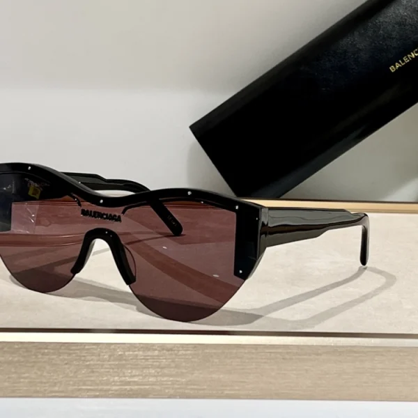 Balenciaga Ski cat-eye sunglasses laid flat on white surface, showing wraparound shield design