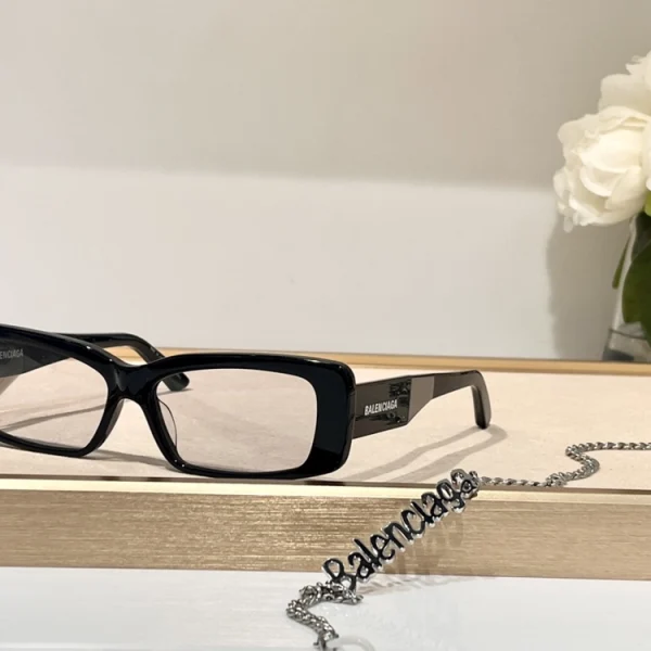 Balenciaga unisex sunglasses laid flat on white surface with minimalist styling