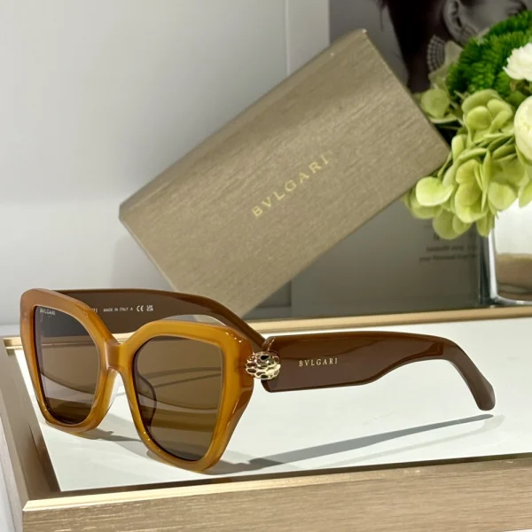 Detailed product shot of Bvlgari Serpenti sunglasses showcasing gold-plated snake-scale hinges