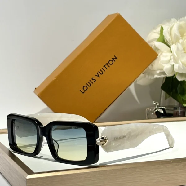 Bvlgari Serpenti sunglasses laid on glossy surface, highlighting serpent-scale detailing and tinted lenses