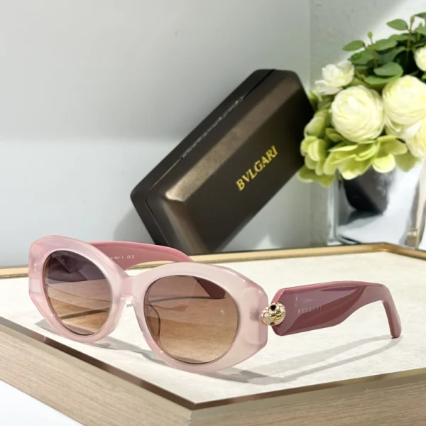 Elegant Bvlgari sunglasses with Serpenti detailing, resting on white marble surface with branded case