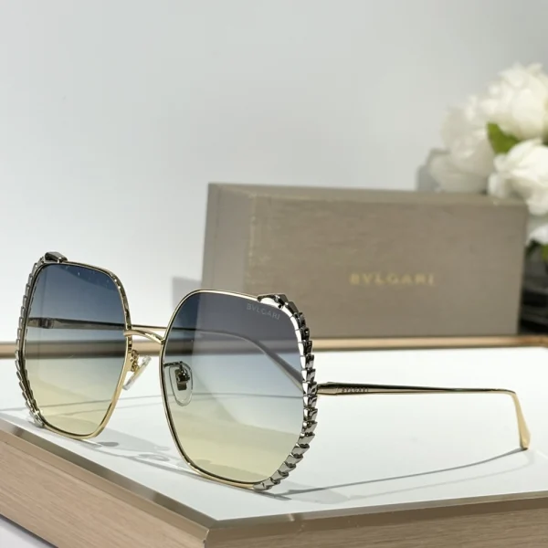 Close-up of Bvlgari Serpenti sunglasses – gold hardware and gradient lenses under natural light