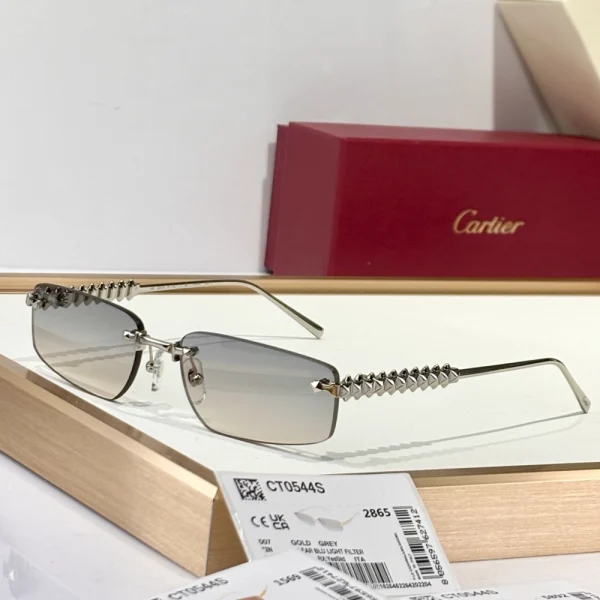 Cartier Clash de Cartier sunglasses placed on a matte white surface, featuring bold temples with studded detailing inspired by the iconic jewelry line