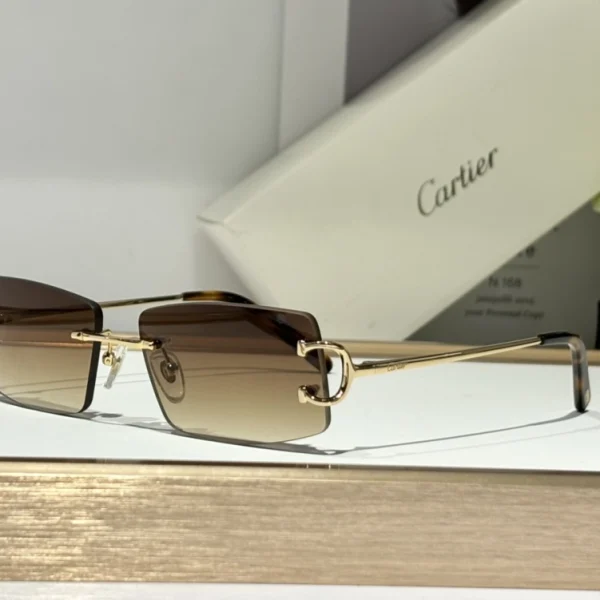 Cartier Décor C classique de Cartier sunglasses with polished gold-tone temples and classic black frame, resting on a white tabletop