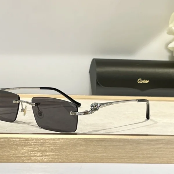 Elegant Cartier Panthère de Cartier sunglasses lying on textured surface, with signature feline detail catching light