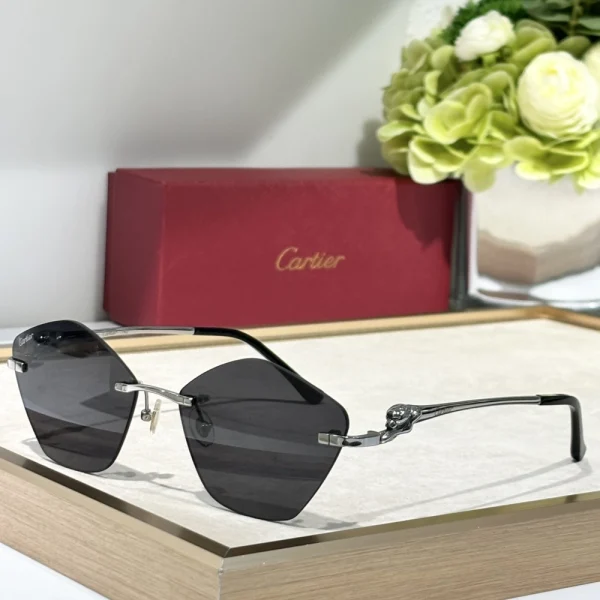 Cartier Panthère de Cartier sunglasses with gold panther motif clinging to the temple, resting on a soft white fabric background