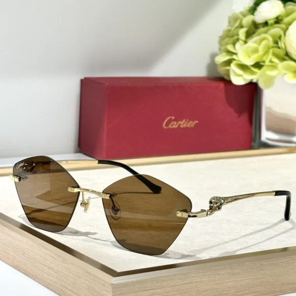Close-up of Cartier Panthère de Cartier sunglasses showcasing panther head with green gem-like eyes on glossy black frame