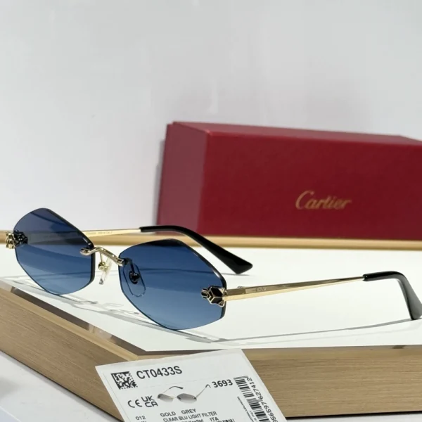 Cartier Panthère de Cartier sunglasses displayed on a glossy white surface, showcasing the iconic gold panther detail wrapped around the hinge for a bold yet elegant finish