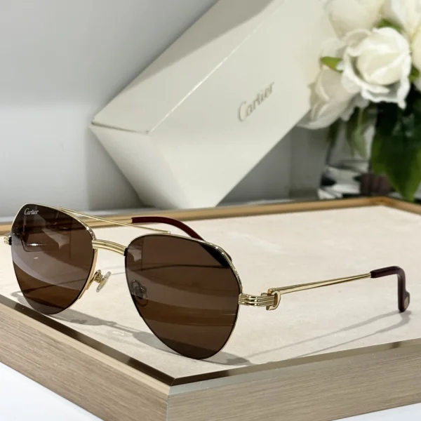 Première de Cartier sunglasses by Cartier placed diagonally on glossy white background, with subtle shadows for depth