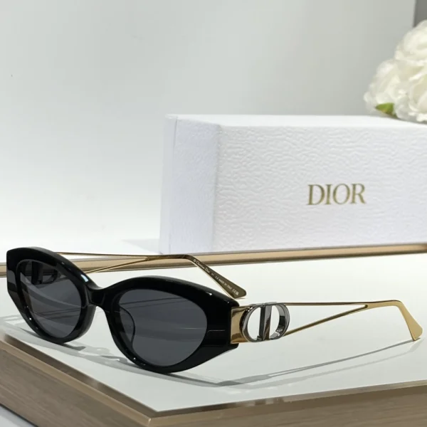 Black Dior 30Montaigne B6F sunglasses resting on a marble surface under soft daylight