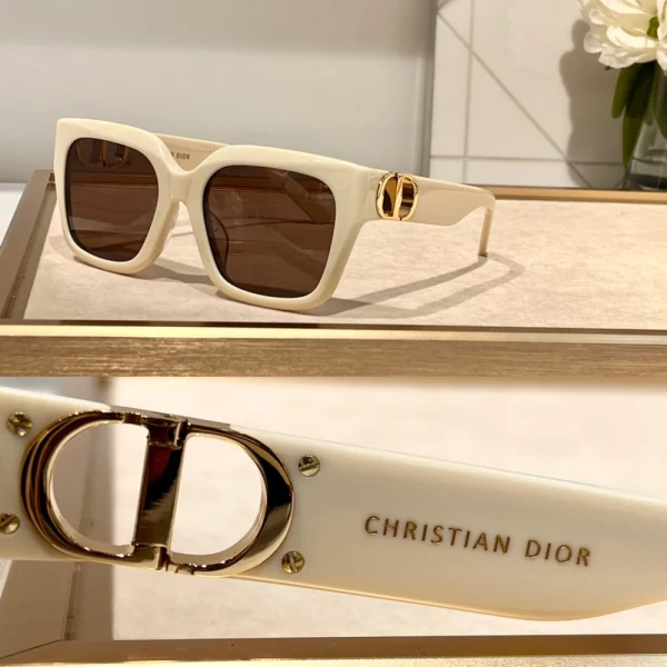 Luxury Dior 30Montaigne S10F sunglasses placed diagonally on marble surface under natural daylight