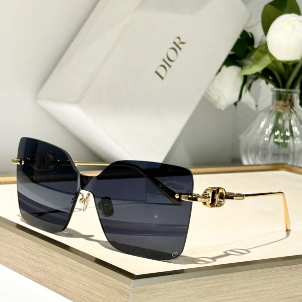 Close-up of Dior CD Chain M1U sunglasses highlighting gold chain-link temple design and engraved CD logo
