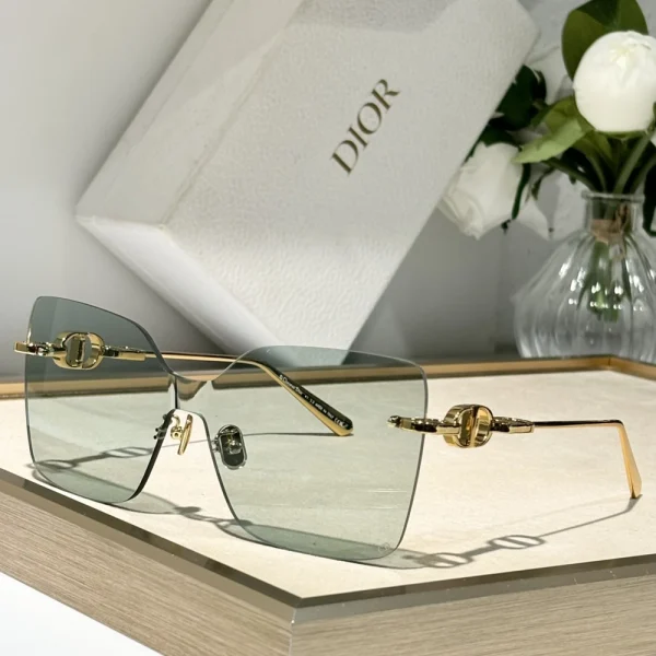 Elegant Christian Dior CD Chain M1U sunglasses resting on a marble tabletop with branded Dior case in the background