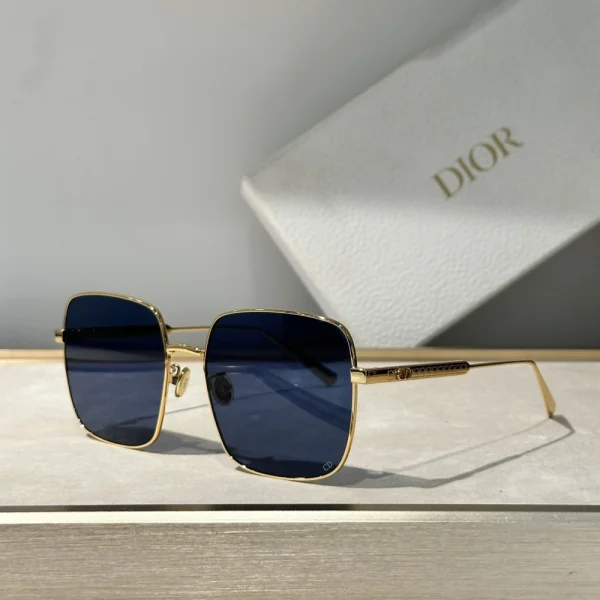 Christian Dior DiorCannage S1U sunglasses with oversized square black frame and gradient lenses, styled on a clean white tabletop