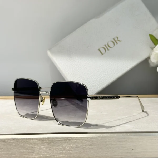 Elegant Christian Dior DiorCannage S1U sunglasses resting beside branded Dior eyewear case and microfiber cleaning cloth