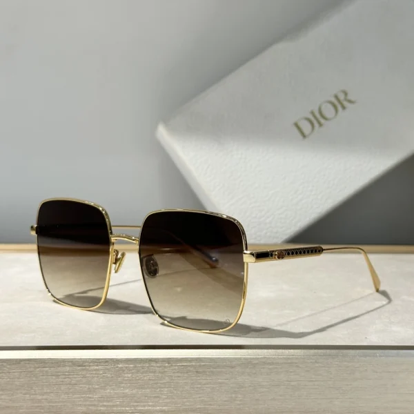 Luxury Dior DiorCannage S1U sunglasses placed diagonally on a marble surface under natural daylight