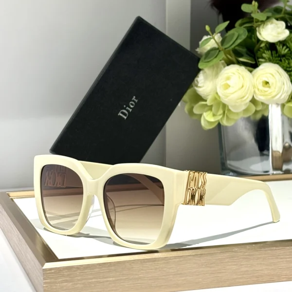 Christian Dior MissDior S2F sunglasses with elegant butterfly frame in glossy black and gradient lenses, styled on a white tabletop