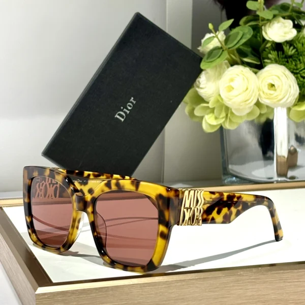 Elegant Christian Dior MissDior S2F sunglasses resting beside branded Dior case and microfiber cleaning cloth