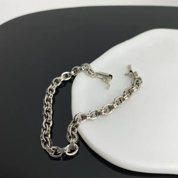 Unisex Chrome Hearts silver bracelet with paper-style links, blending iconic design and urban fashion.