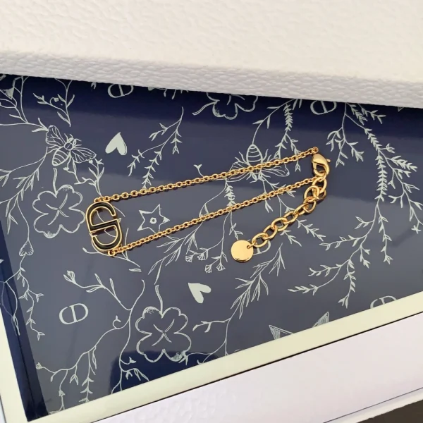 Close-up of Dior bracelet featuring gold-tone CD logo charm