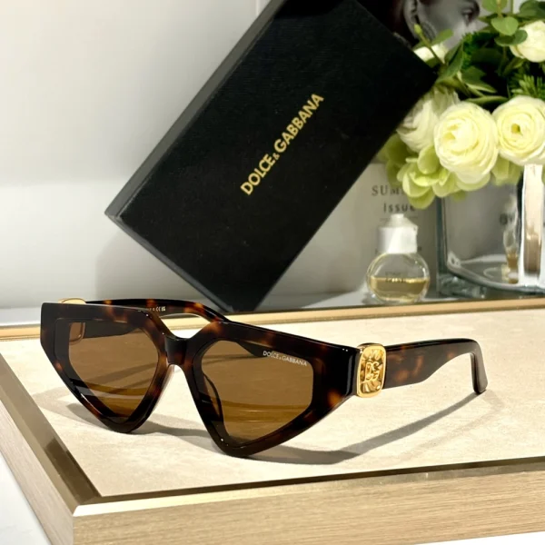 Close-up of Dolce & Gabbana DG Precious sunglasses showcasing intricate gold detailing and sleek black frames