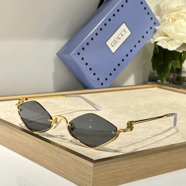 Close-up of Gucci geometric sunglasses with sharp edges and gold Gucci logo at the temples