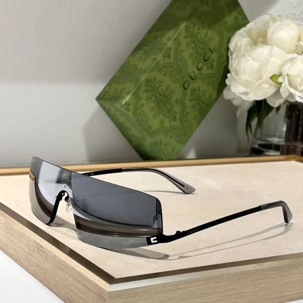 Close-up of Gucci mask-style sunglasses featuring curved one-piece lens and iconic logo detail