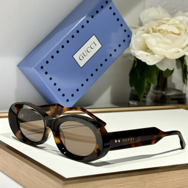 Classic Gucci oval sunglasses featuring tinted lenses and gold-tone temple details