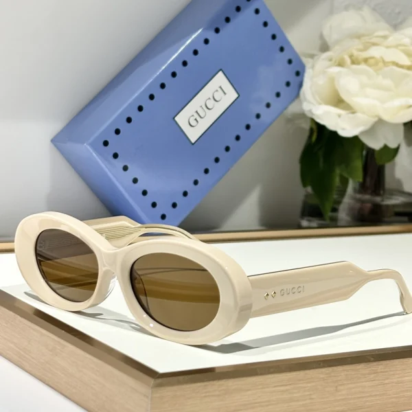 Close-up of Gucci oval sunglasses showing delicate curves and subtle logo engraving