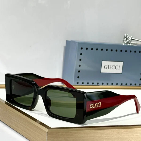 Close-up of Gucci rectangular sunglasses in glossy black acetate with subtle gold logo on temples