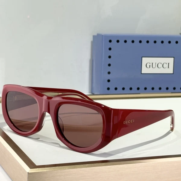 Classic Gucci rectangular sunglasses resting on textured fabric, with shadows adding depth