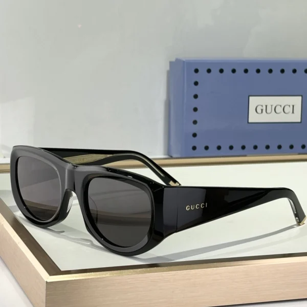 Gucci rectangular-frame sunglasses paired with branded case, photographed under soft natural light
