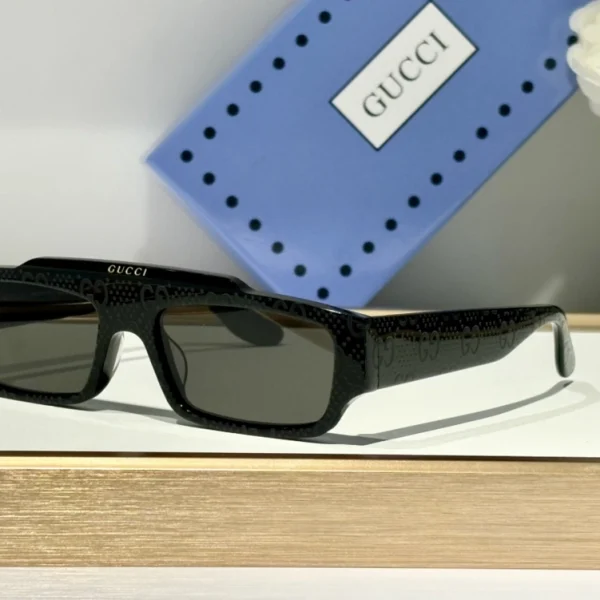 Luxurious Gucci rectangular sunglasses with polished finish, photographed alongside branded case and accessories