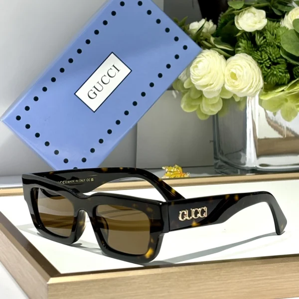 Gucci GG-SG60 rectangular sunglasses placed on textured surface under soft lighting