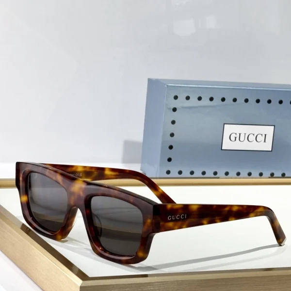 Gucci square-frame sunglasses laid flat on white background, with case and cleaning cloth visible
