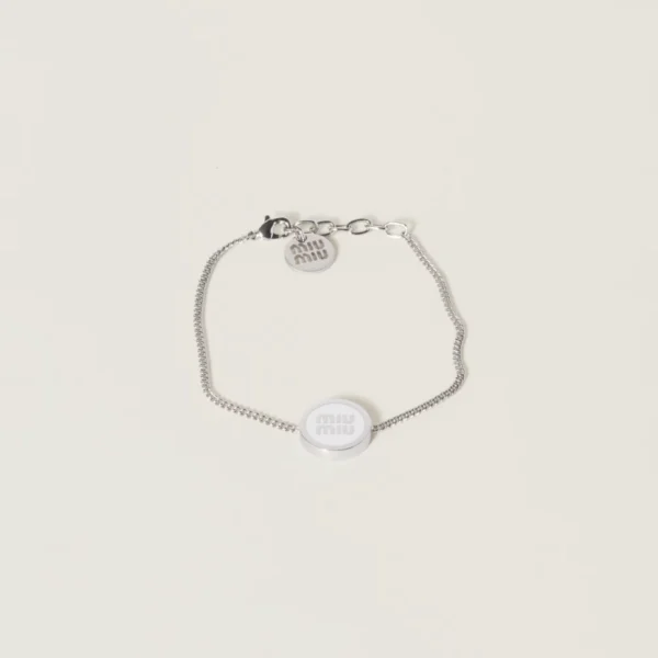 Fashion bracelet in the style of Miu Miu featuring white enamel and polished metal