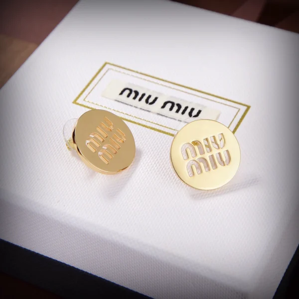 Close-up of Miu Miu earrings with bold logo design and sleek modern finish