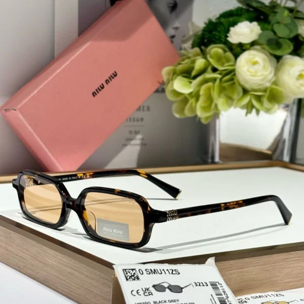 Flat lay of Miu Miu Miu MM-SG42 sunglasses with elegant ombré lenses and minimalist frame design