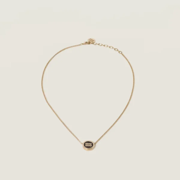 Elegant Miu Miu black metal necklace styled with contemporary fashion outfit