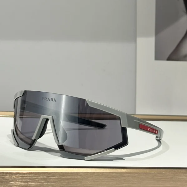 Side angle of Prada Linea Rossa Impavid sunglasses showing sculpted arms and iconic red line on the temple