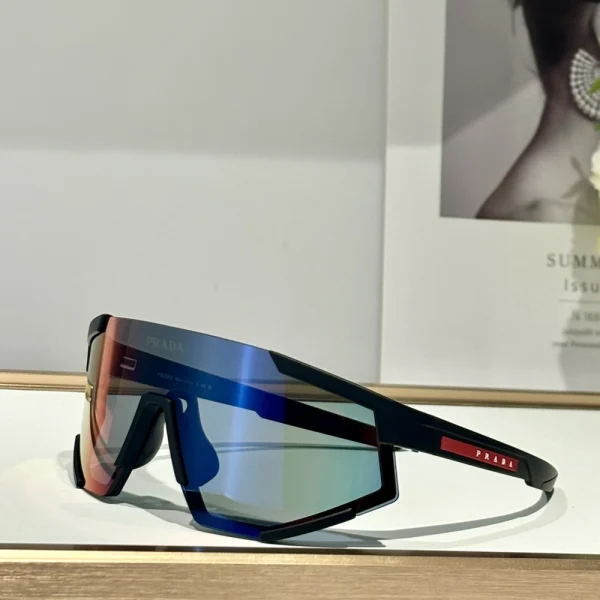 Matte grey Prada Linea Rossa Impavid sunglasses with bold wrap lens, styled on outdoor concrete background
