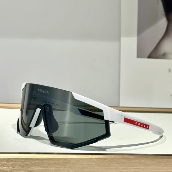 Prada Linea Rossa Impavid sunglasses featured in flat lay with sporty accessories, reflecting dynamic lifestyle design
